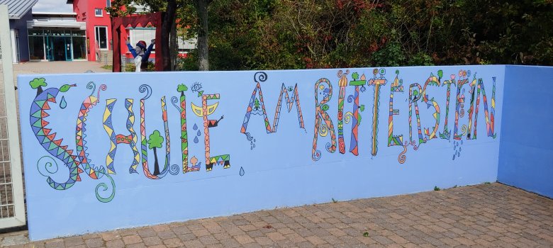 Schriftzug "Schule am Ritterstein" Eingang Mauer